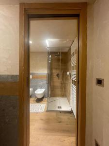 een badkamer met een glazen douche en een toilet bij Affittacamere L'Abri in Etroubles +30 foto's