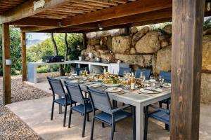 une table dressée pour un repas sur une terrasse dans l'établissement Villa Porto-vecchio 4 chambres avec piscine, à Porto-Vecchio