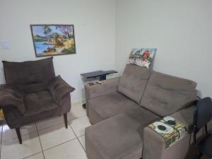 a living room with a couch and a chair at Apart próximo a Unimed, Catedral e HSA com 2 quartos com 2 ARES e garagem in Santo Ângelo