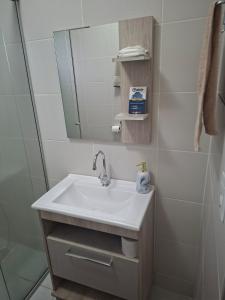 a bathroom with a sink and a mirror at Apart próximo a Unimed, Catedral e HSA com 2 quartos com 2 ARES e garagem in Santo Ângelo +57 photos