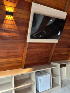 een tv in een kamer met een houten muur bij Pousada Vasto Horizonte in Barreirinhas
