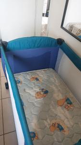 a toddler bed in a room with a blue mattress at Apart próximo a Unimed, Catedral e HSA com 2 quartos com 2 ARES e garagem in Santo Ângelo