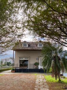 ein Haus mit einer Palme davor in der Unterkunft 稻哪趣田園民宿 平價villa in Dongshan