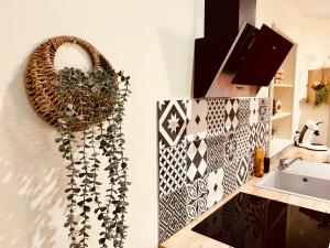 ein Badezimmer mit einer Pflanze an der Wand und einem Waschbecken in der Unterkunft Comme chez soi - Emplacement #1 et Grand Confort in Feurs