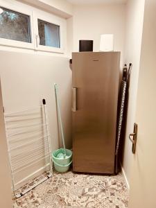 eine Küche mit Kühlschrank und Wischmopp in der Unterkunft Comme chez soi - Emplacement #1 et Grand Confort in Feurs