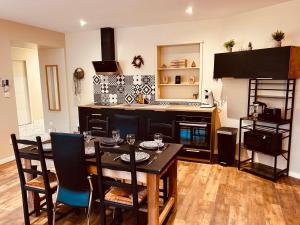 eine Küche mit Tisch und Stühlen in einem Zimmer in der Unterkunft Comme chez soi - Emplacement #1 et Grand Confort in Feurs