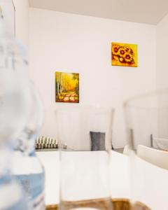 een witte kamer met twee schilderijen aan de muur bij Stacja Binino 