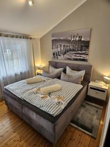 een slaapkamer met een groot bed met een schilderij aan de muur bij Domizil am Park in Kressbronn am Bodensee