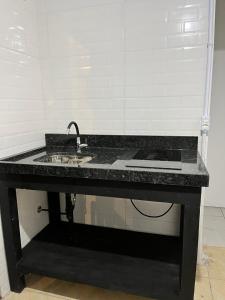 een zwart aanrecht met een wastafel in een kamer bij Moradas do Embaú in Palhoça +13 foto's