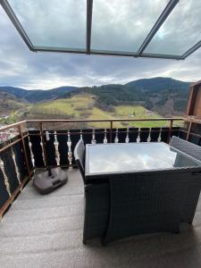 een tafel en stoelen op een balkon met uitzicht bij Ferienwohnung Inge in Bad Peterstal +17 foto's