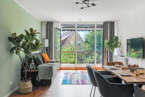 ein Wohnzimmer mit einem Tisch und Stühlen sowie einem großen Fenster in der Unterkunft ARCHIPEL-Nahe Hamburg-Terasse-Neu in Geesthacht