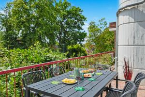einen Holztisch mit Weingläsern und Speisen auf dem Balkon in der Unterkunft ARCHIPEL-Nahe Hamburg-Terasse-Neu in Geesthacht