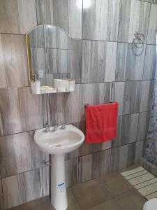 a bathroom with a sink and a mirror at Casita Rosa II in San José