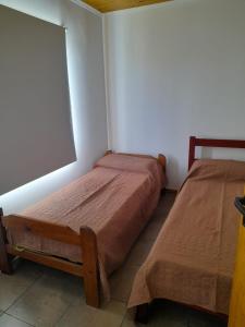 two beds in a room with a large screen at Casita Rosa II in San José