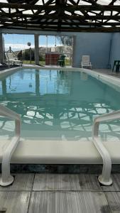 una grande piscina con due sedie intorno di Quartos Beira Mar ARROIO TEIXEIRA a Capão da Canoa