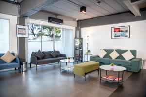 ein Wohnzimmer mit Sofas und Tischen in der Unterkunft IU Hotel Donmueang Airport in Ban Don Muang