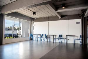 ein Zimmer mit Stühlen und Tischen in einem Gebäude in der Unterkunft IU Hotel Donmueang Airport in Ban Don Muang