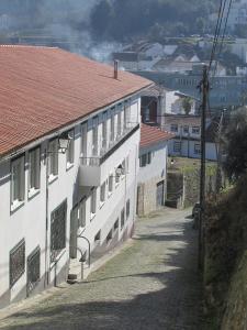 a white building with a red roof on a street at Lavanda Termas de São Pedro do Sul in Termas de Sao Pedro do Sul