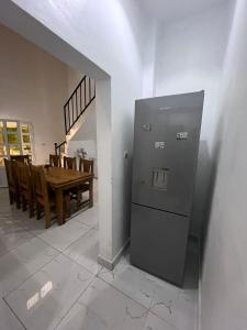 een keuken en eetkamer met een koelkast en een tafel bij Terranga in Mbour