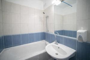 een badkamer met een wastafel en een ligbad bij Comfort 28 Great Value Apartment in Miskolc +6 foto's