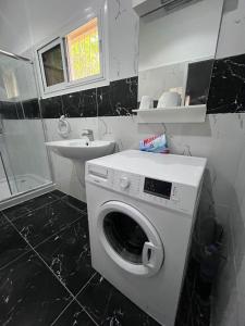 een badkamer met een wasmachine en een wastafel bij Terranga in Mbour