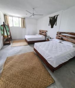 een slaapkamer met 2 bedden en 2 tapijten bij Tropic Bacalar in Bacalar