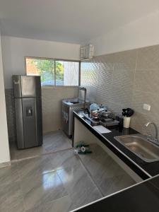 een keuken met een spoelbak, een fornuis en een koelkast bij Apartamentos King Arthur in Punta Seca