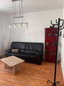een woonkamer met een zwarte leren bank en een tafel bij Mathilde in Quedlinburg