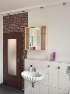 een badkamer met een witte wastafel en een spiegel bij Mathilde in Quedlinburg