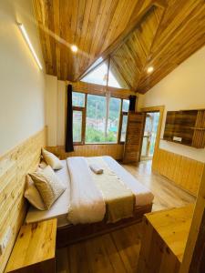 a large bed in a room with a large window at The Himalayan Castle View Retreat in Nagar