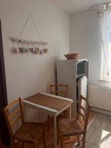een keuken met een tafel, stoelen en een koelkast bij Mathilde in Quedlinburg +4 foto's