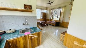 a kitchen with a sink and a living room at The Himalayan Castle View Retreat in Nagar +14 photos