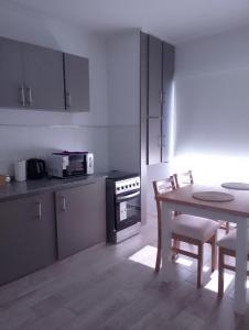 - une cuisine avec une table, une table et des chaises dans l'établissement El Estudio Céntrico con cochera, à Lobos