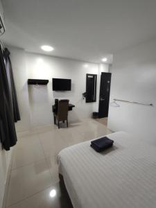 a bedroom with a bed and a desk in a room at comfortpahlawan in Sibu