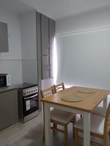 - une cuisine avec une table et des chaises en bois dans l'établissement El Estudio Céntrico con cochera, à Lobos 2 autres photos
