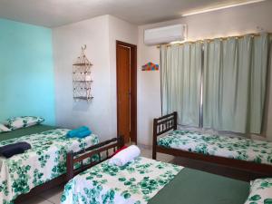 une chambre avec deux lits et une fenêtre dans l'établissement Aquarela Suítes, à Piúma