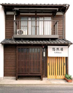 un edificio con un cancello e un cartello sopra di 悠然居SR Inn a Kyoto