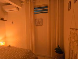 a bedroom with a bed and a door with a window at ptit coin hibiscus in Pointe-Noire