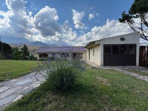 a house with a garage and a grass field at El Mirador in Potrerillos