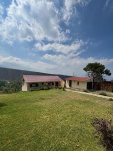 a house with a grassy yard in front of it at El Mirador in Potrerillos