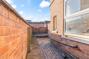 un vicolo di mattoni con una finestra sul lato di un edificio di NEW! Sleeps 5 - Free Parking - Contractors a Warwick