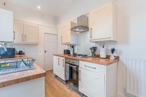 una cucina con mobili bianchi e un lavandino di NEW! Sleeps 5 - Free Parking - Contractors a Warwick