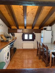 een keuken met een tafel en een koelkast bij Albergue Rural Montebaserria in Ziortza-Bolibar