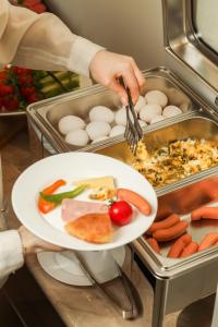 een persoon met een bord voedsel met eieren en groenten bij Barca Hotel in Jerevan