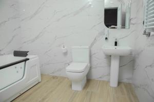 een witte badkamer met een toilet en een wastafel bij Barca Hotel in Jerevan