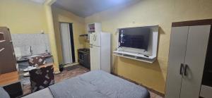 eine Küche mit einem Kühlschrank und einem TV an der Wand in der Unterkunft Cantinho bom! in Manaus + 14 Fotos