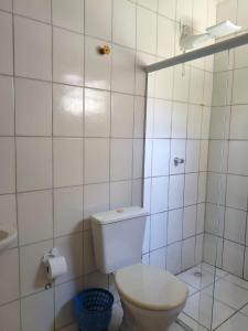een witte badkamer met een toilet en een wastafel bij Aquarela Suítes in Piúma