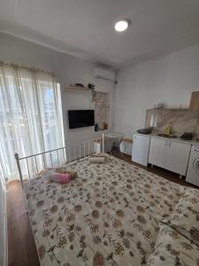 a bedroom with a bed with a rug on the floor at AK mini studio u centru in Tivat