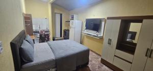 ein Schlafzimmer mit einem Bett und einem Fernseher in einem Zimmer in der Unterkunft Cantinho bom! in Manaus