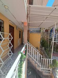 un edificio con un portico e una ringhiera bianca di Hostal la familia a Churín